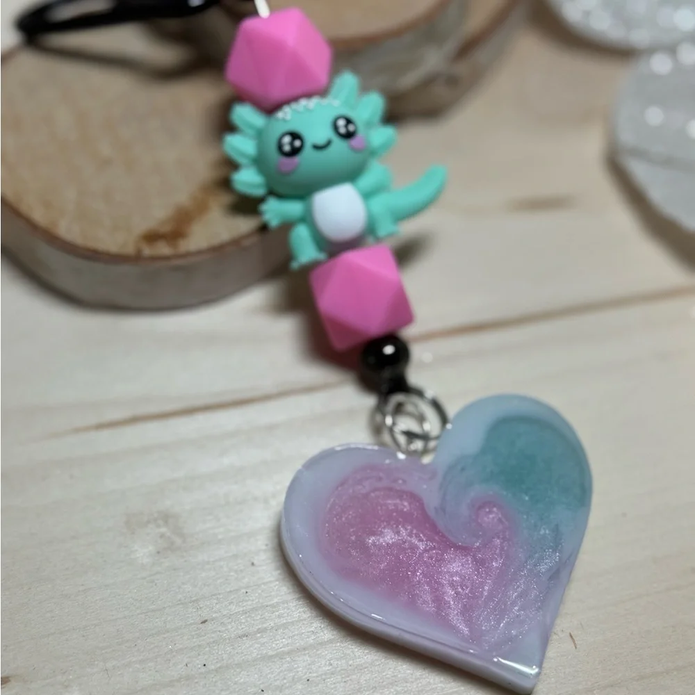 axolotl keychain with a pink and teal or blue resin heart pendant